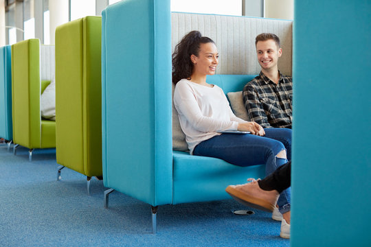 University students relaxing in modern cubicle seating area