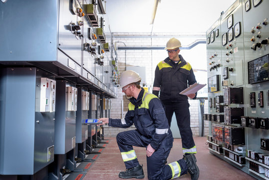 Workers Testing For Noise In Electricity Substation