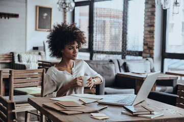 Enjoying coffee at her working place. 