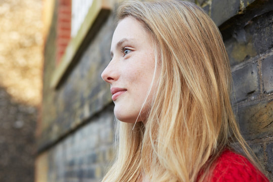 Portrait of young woman outdoors, looking away