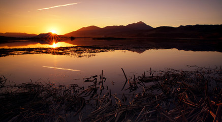 Colorful sunset over lake and mountains