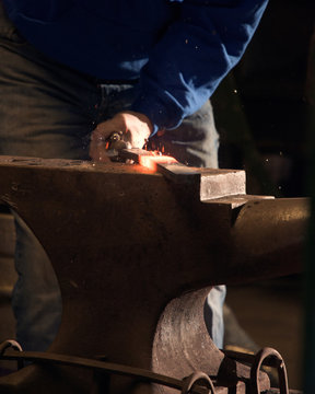 Farrier forging horseshoe on anvil