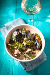 Mussels in Roquefort sauce  on the cyan background vertical