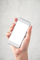 Male hand holding mobile phone with blank mock up screen