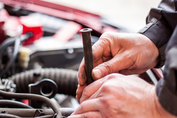 Mechanic checks the cables that are connected spark plugs with petrol