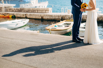 Newlyweds hold hands on the sea. Couple holding hands. Wedding in Montenegro.
