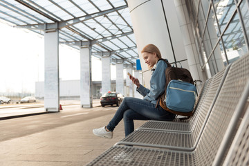 Cheerful female watching at cellphone outdoor