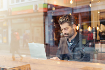 man working on a digital project in a cafe