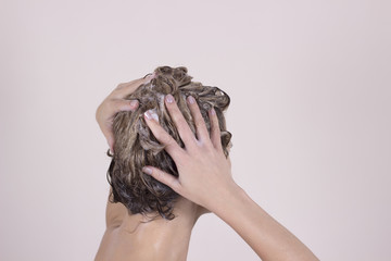 Young attractive woman washing her beautiful long hair