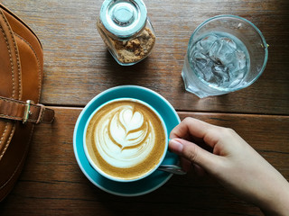 Cup of coffee with beautiful Latte art with human hand prepare for drink
