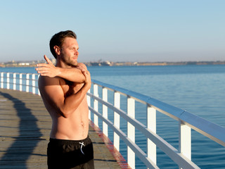 Swimmer stretching on boardwalk, Eastern Beach, Geelong, Victoria, Australia