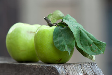 Two apples on a wooden surface