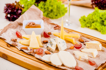 Cheese platter with honey, nuts and grape