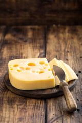 Delicious Swiss yellow cheese on dark wooden rustic background closeup