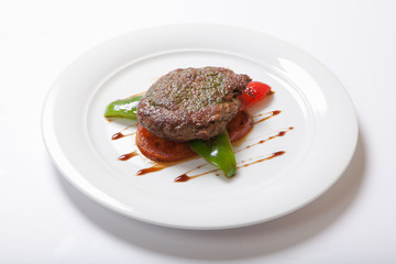 Grilled steaks and vegetables on a white plate