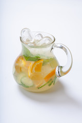 Jug with orange cucumber refreshing drink, rustic style, selective focus