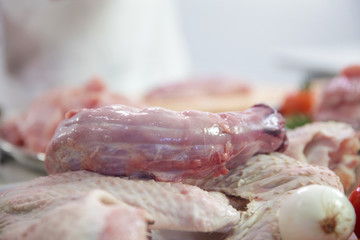 Lots of different kinds of meat are on the table and a chef is preparing dinner.