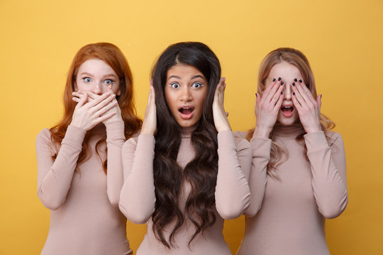 Three women covering their ears, eyes and mouth