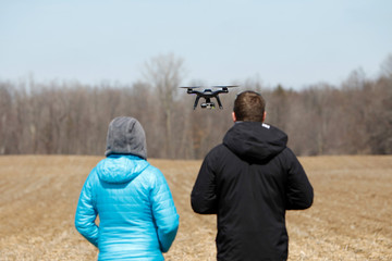 A young couple flying a drone