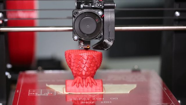3d printer is typing 3d model of a red owl. The video is shot close-up. This video was shot using Canon 5d Mark 3. If you liked this video, rate it, please!