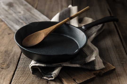Cast iron frying pan on country rustic wooden/timber background