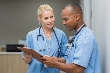 Nurses checking medical reports - obrazy, fototapety, plakaty