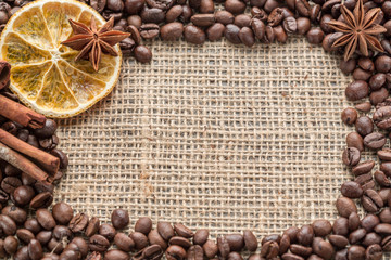 Coffee beans and illicium on a background of burlap. Roasted coffee beans background close up....