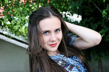 Naklejka premium Smiling brunette on the nature of the spring