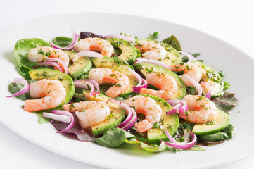 salad a-la carpaccio with prawns, avocado, and red onion sprinkled with black pepper and dressed with olive oil, lemon juice, and finely chopped parsley 
