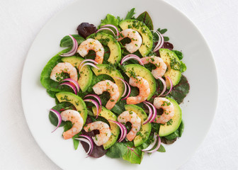 green salad with prawns, avocado, and red onion sprinkled with black pepper and dressed with olive oil, lemon juice, and finely chopped parsley 