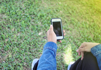 hand hold phone in morning green grass background