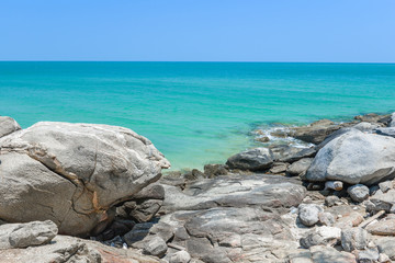 Fototapeta na wymiar Rocks on the seashore with blue sea water