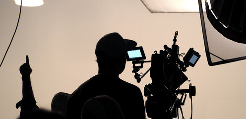 Behind the scenes of silhouette working people or video production film crew are making movie or...