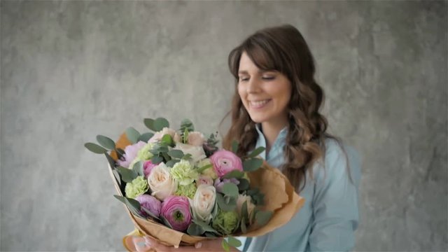 Portrait of happy female florist with bouquet roses and peone looking at camera