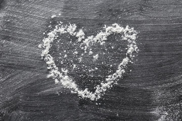 Heart made of flour on dark background