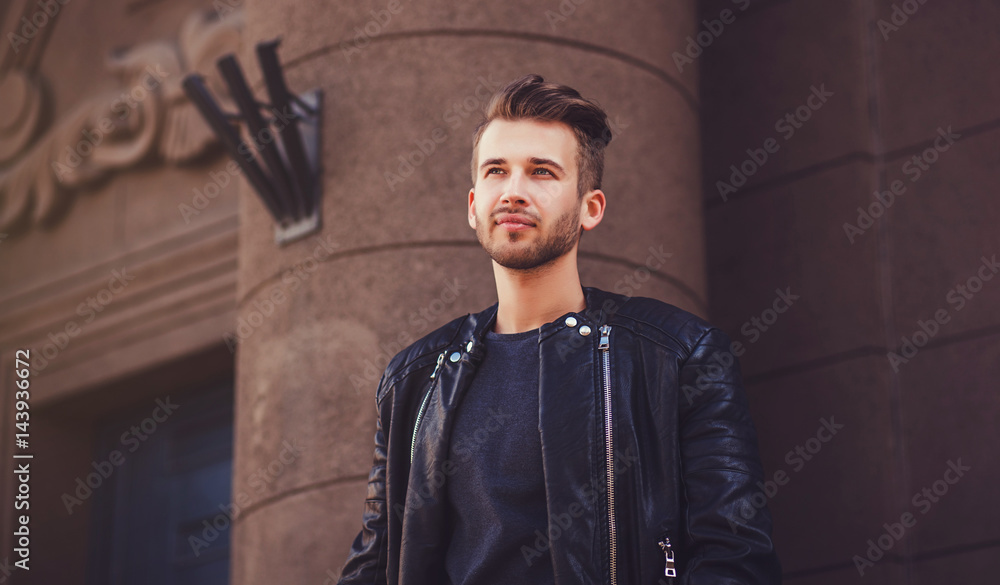 Wall mural handsome young man in jacket smiling outdoors