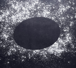 Oval frame made of flour on dark background