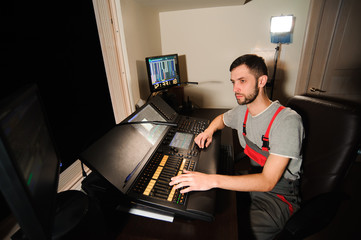 A lighting engineer works with lights technicians control on the concert show. Professional light...