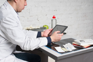 Doctor filling medical online form in the laptop tablet. The works at the hospital