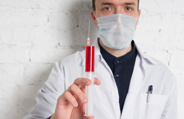 Doctor holds in a hand syringe inside the injection of vitamin