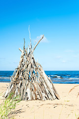 Wigwam Made from wooden branches on the sand of baltic sea beach