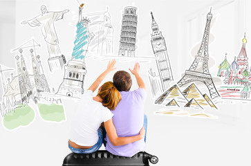 Couple planning their trip around the world and picking places to visit sitting on travel case