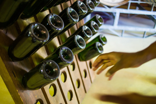 Close up image of lots of champagne bottles in a bottle rack in a wine cellar