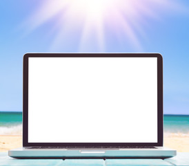 Modern laptop on blue wooden table with blank screen at tropical beach