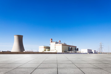 empty floor with power plant in blue sky
