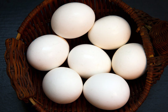 White chicken eggs in a wicker basket. Natural rustic food that gave birth to birds. Easter still life eggs clean.