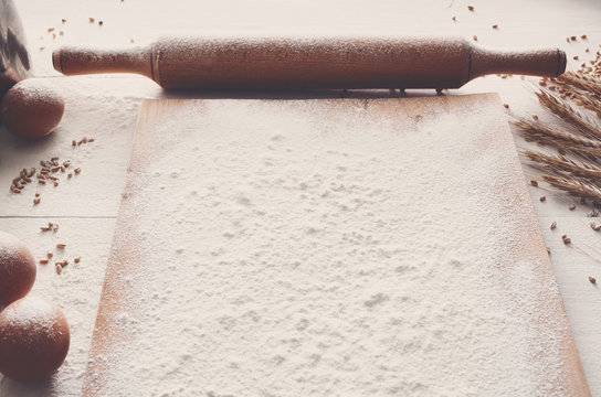 Baking concept on white wood background, sprinkled flour with copy space