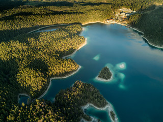 Aerial view shot by a drone of the Eibsee with islands and trees on the lake shore