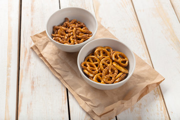 Pretzels in bowls on wooden table from above