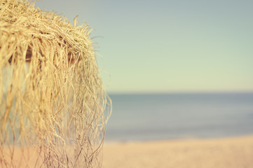 Holiday beach chaise lounges and parasol canopy on the ocean outdoors background